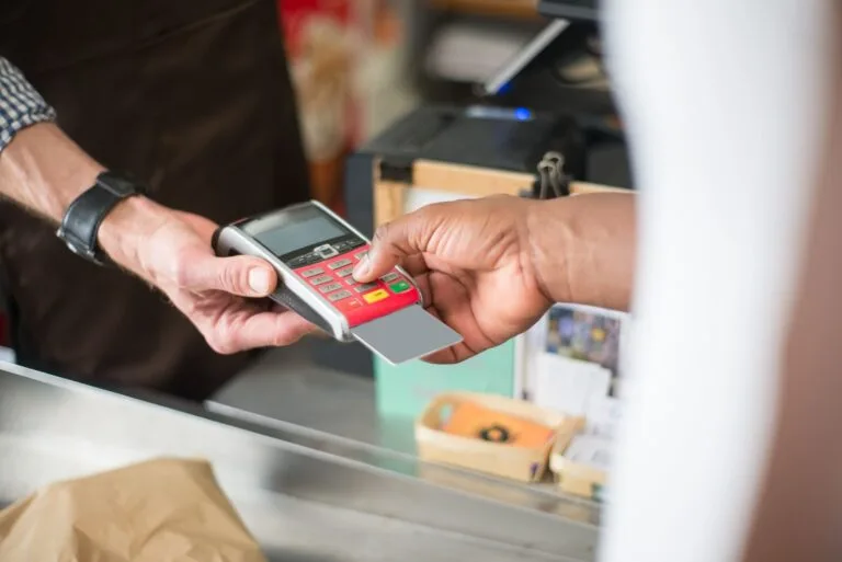 A customer uses a card for a contactless payment at a retail store. Business and consumeri