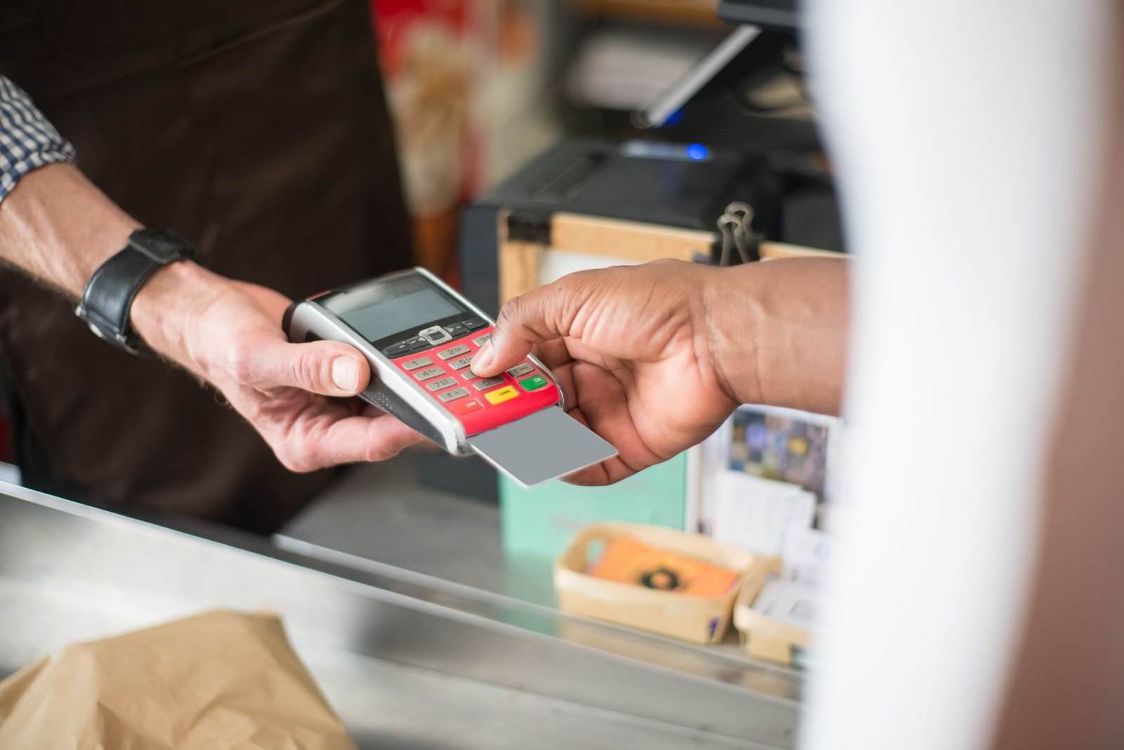 A customer uses a card for a contactless payment at a retail store. Business and consumeri