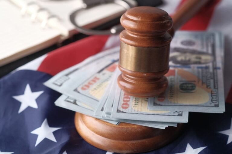 Close-up of a judge's gavel resting on US dollar bills and an American flag, symbolizing j