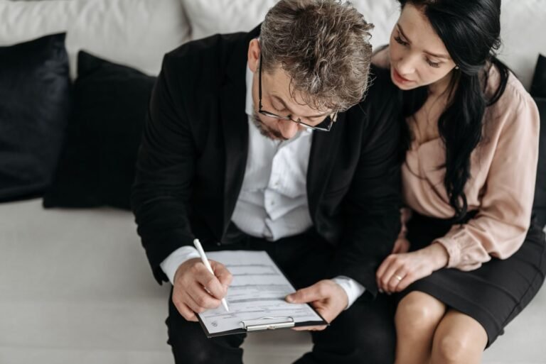 An adult couple sitting together reviewing documents in a modern indoor setting.