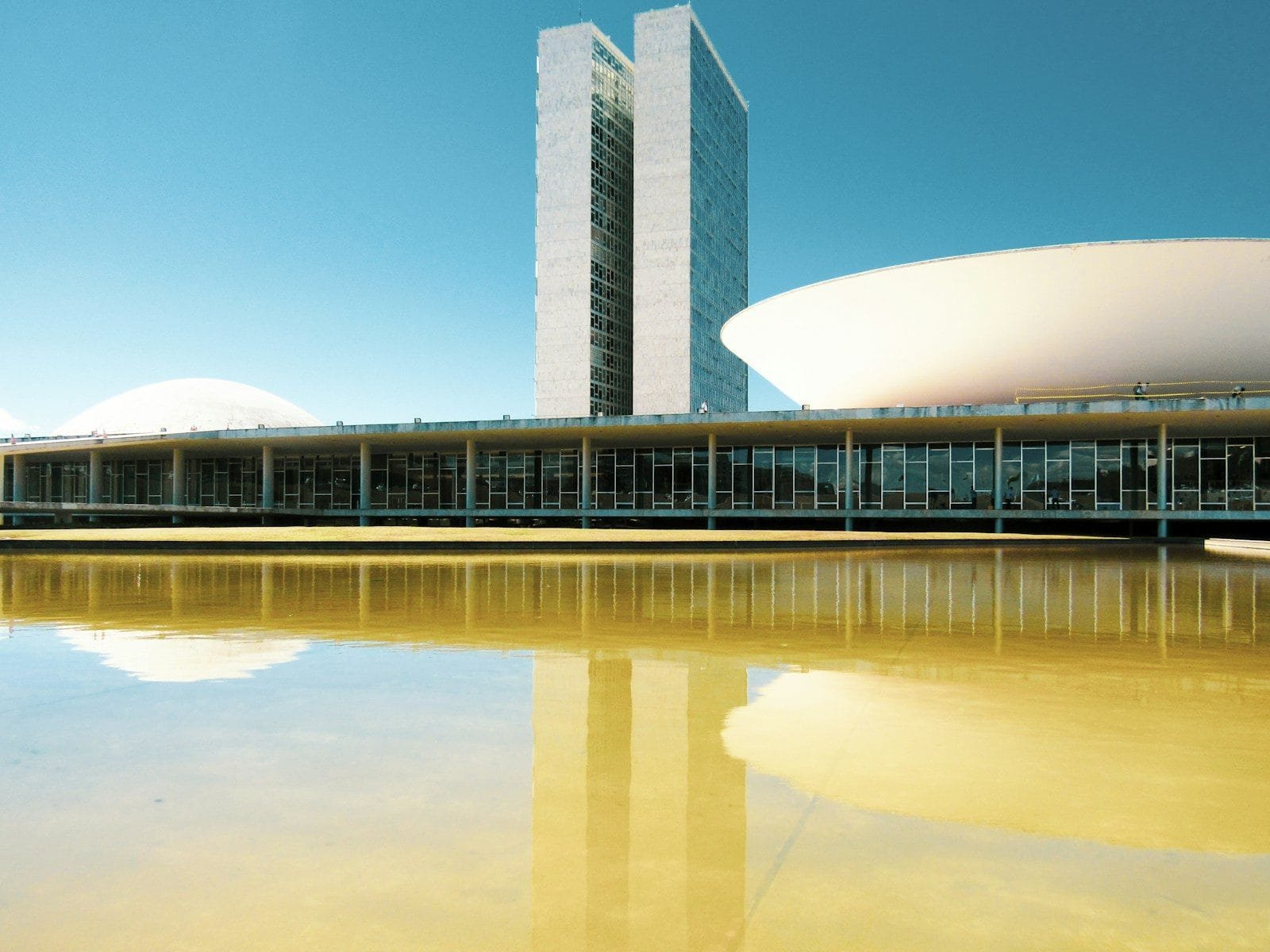 Regulação de IA em Saneamento e Recursos Hídricos 1 white and brown concrete building under blue sky during daytime