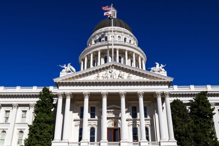 Sunlit view of the California State Capitol with clear blue skies.