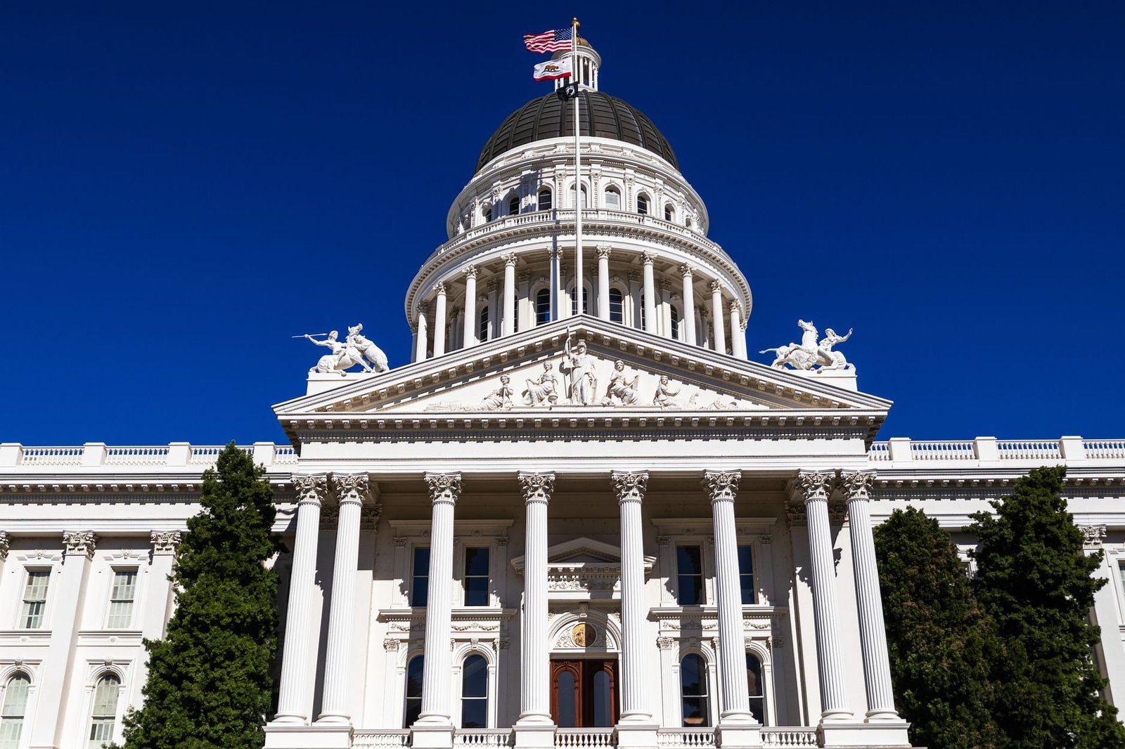 Sunlit view of the California State Capitol with clear blue skies.