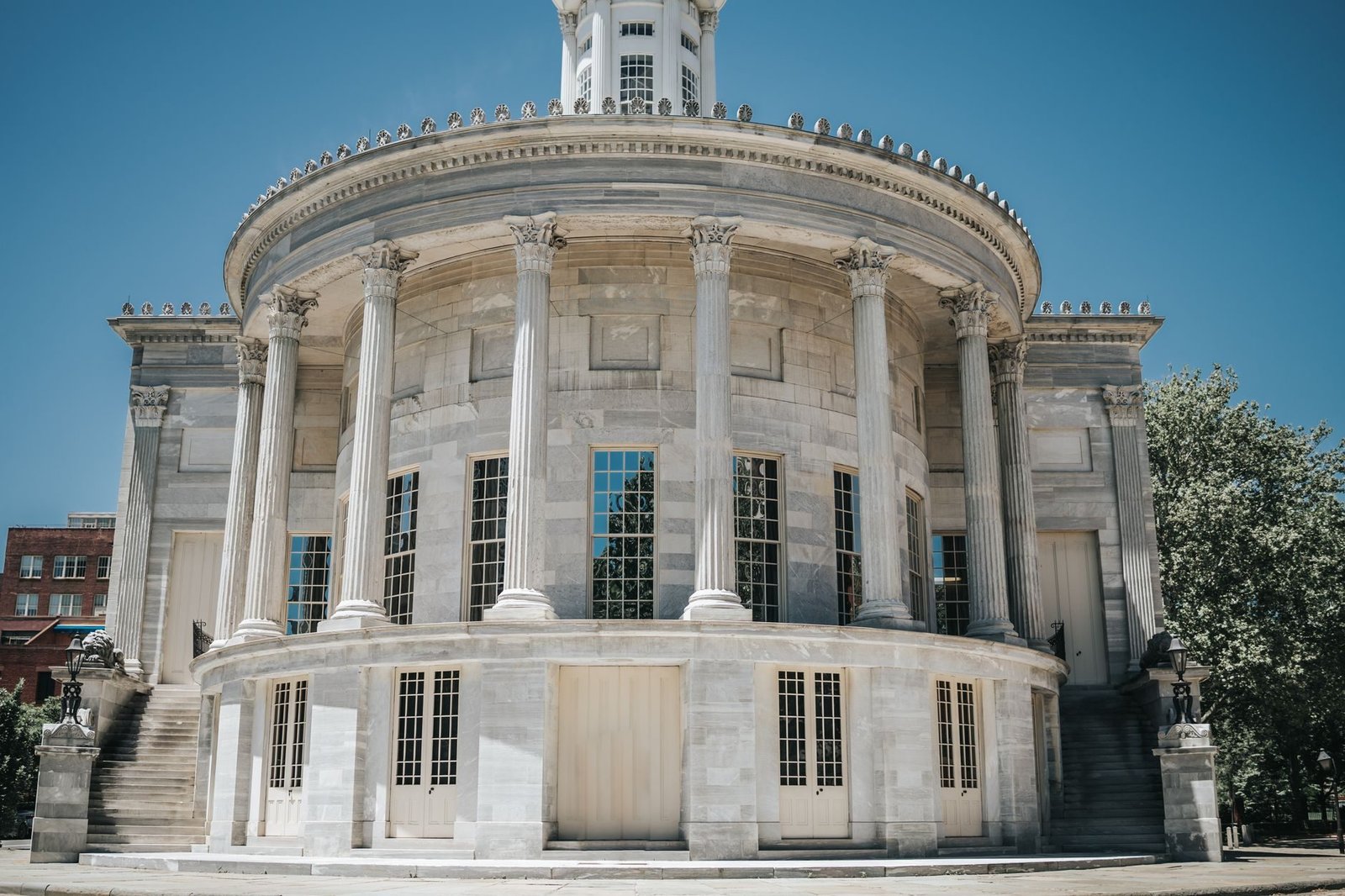 Responsabilidade do Estado por omissao: quando deixar de agir gera o dever de indenizar 1 A neoclassical building with columns against a clear blue sky, in an urban town setting.