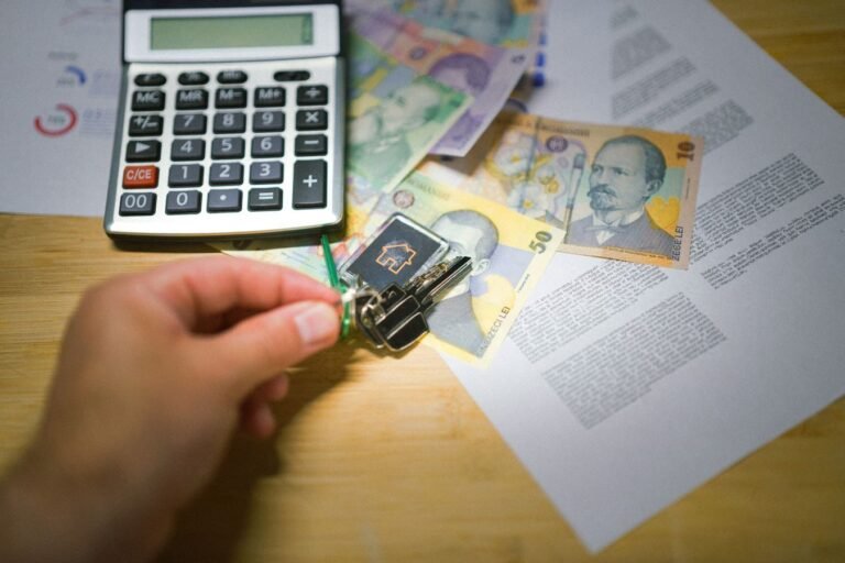 Responsabilidade tributaria dos socios: quando o patrimonio pessoal responde 6 A hand holds keys next to Romanian currency, a calculator, and documents, symbolizing real estate transactions.