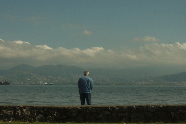 A person stands alone near a coast in Kocaeli, Türkiye, under a cloudy sky.