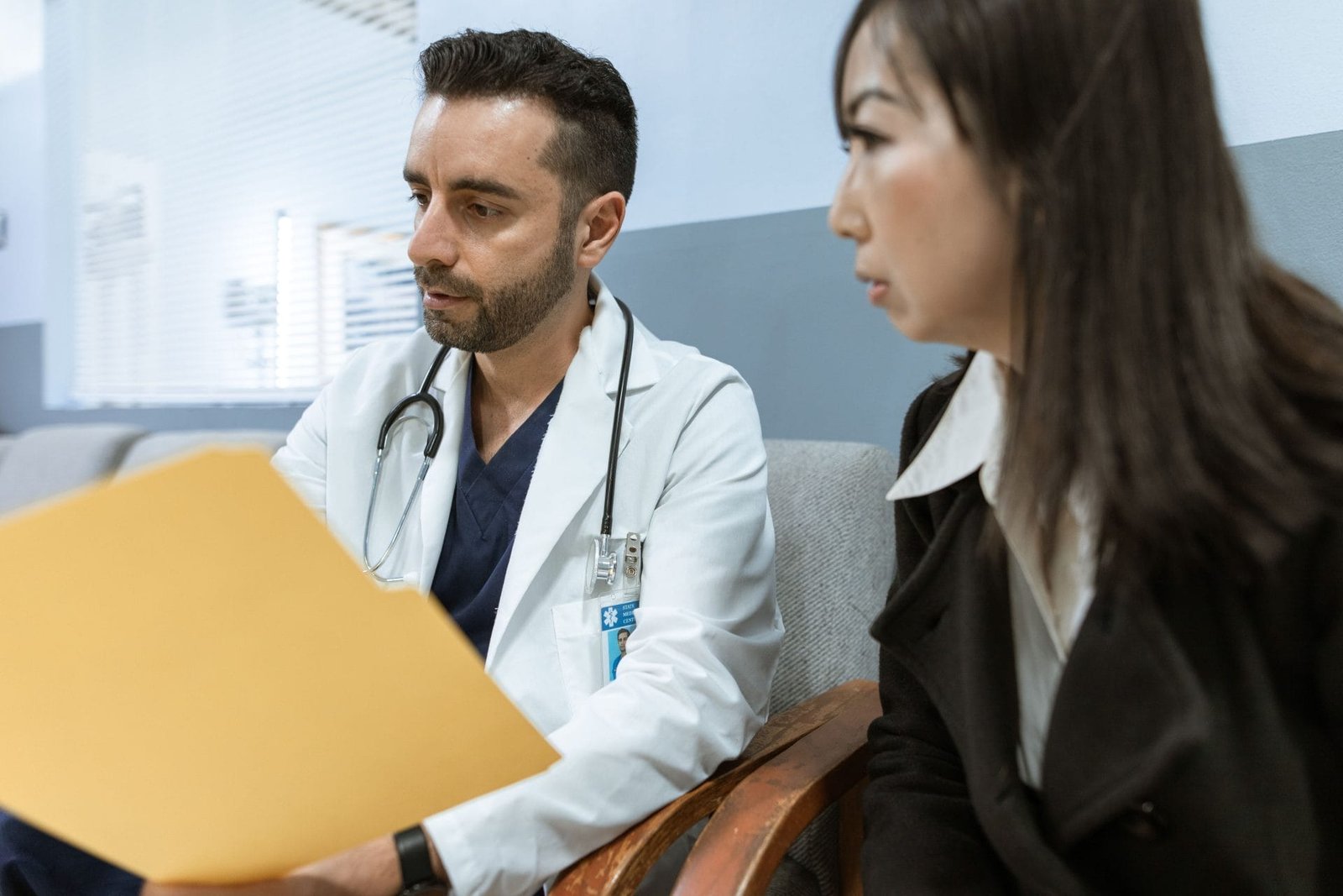 Sequela de Acidente de Trabalho: Direitos e Benefícios 1 Doctor discusses health records with a patient in a clinical setting.