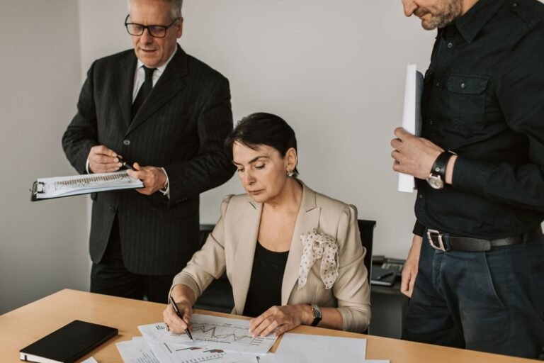 STF decide que o teto remuneratório incide antes do redutor de 70% no cálculo da pensão por morte de servidor (Tema 1.167, ARE 1.314.490) — fevereiro de 2026 3 Business professionals collaborating on financial documents in an office setting.