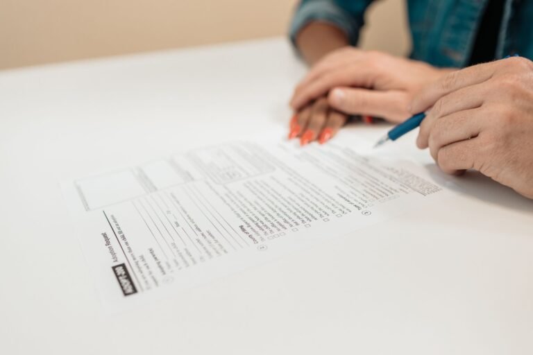 Close-up of hands signing adoption papers in an office environment, symbolizing family and