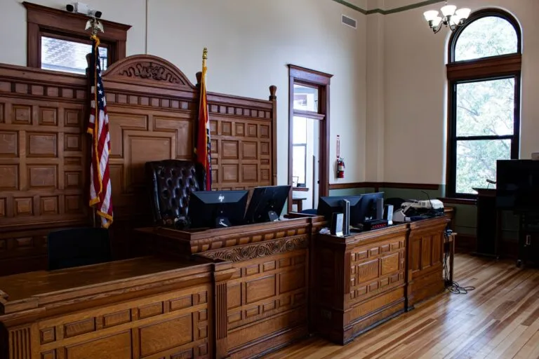 Interior view of an American courthouse in Kirksville, Missouri, featuring a judges desk and flags.