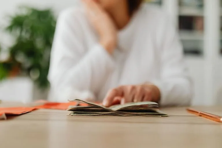 STJ reconhece tempo de atividade especial do contribuinte individual não cooperado, sem exigência de formulário empresarial (Tema 1.291) 3 A woman sitting at a desk sorting through cash, focusing on household budgeting.