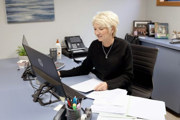 Woman works on laptop at her office desk.