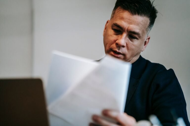 TNU autoriza fixação de efeitos financeiros na DIB/DER quando há complementação de alíquota de contribuinte individual e MEI (Tema 359) 3 Professional man intently reviewing paperwork at his workstation indoors.