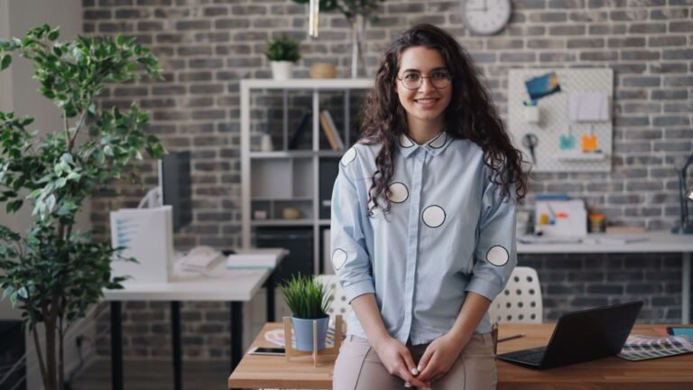 TNU autoriza fixação de efeitos financeiros na DIB/DER quando há complementação de alíquota de contribuinte individual e MEI (Tema 359) 2 Smiling businesswoman with eyeglasses in a contemporary office environment, exuding confidence and professionalism.