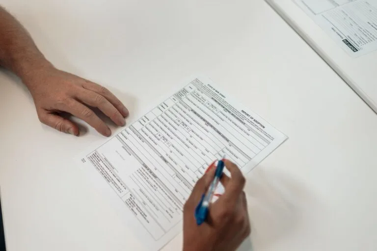 Two people reviewing and signing adoption documents, symbolizing legal procedures and fami