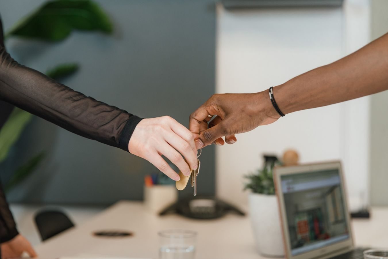 Trespasse: o que verificar ao comprar ou vender um estabelecimento comercial 1 Professional office setting showing a key exchange symbolizing a business deal or real estate transaction.