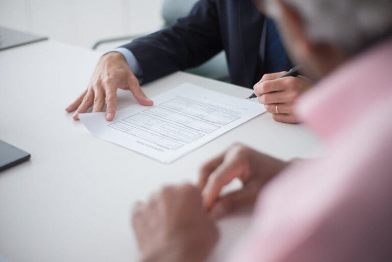 Acordo de sócios: por que toda sociedade deveria ter um 5 Two professionals engaging in a business meeting, signing documents for a consulting agreement.