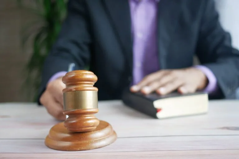Violência Doméstica: Lei Maria da Penha e Medidas Protetivas 4 A wooden gavel and legal book represent justice in a court setting, emphasizing order and legal authority.