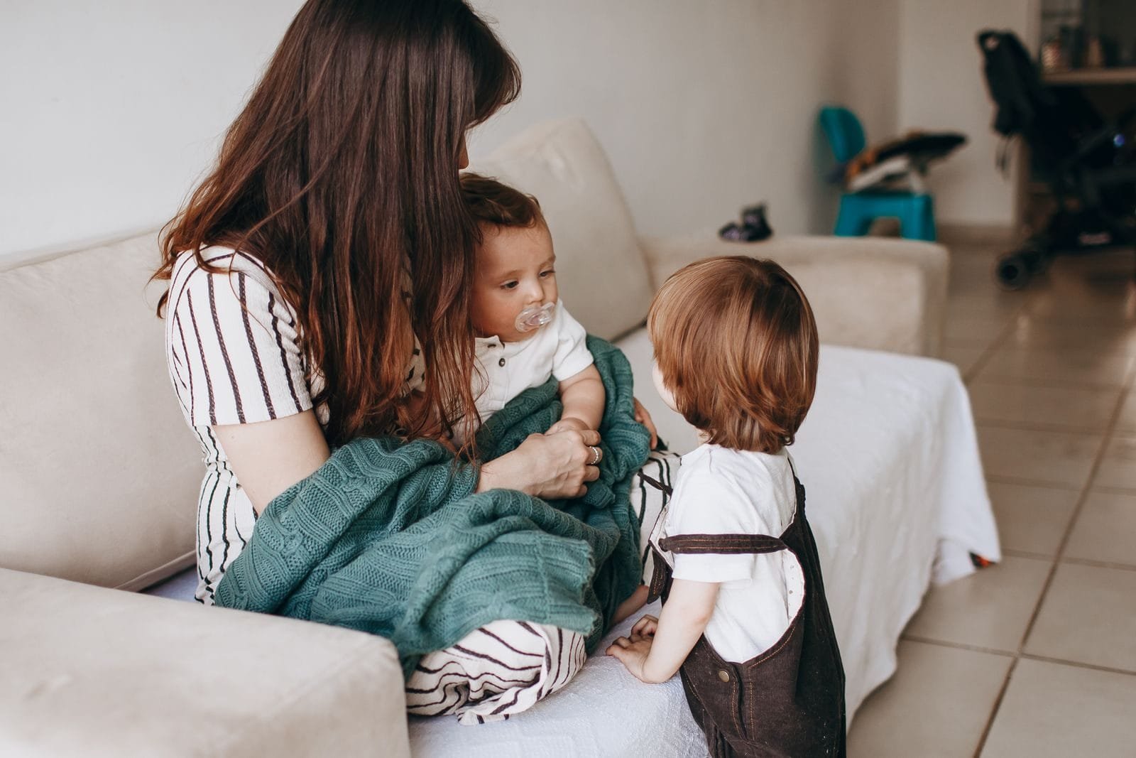 Ação Regressiva INSS Feminicídio 2026: Como Funciona 1 Mother and children share a warm moment on the sofa, filled with love and togetherness.