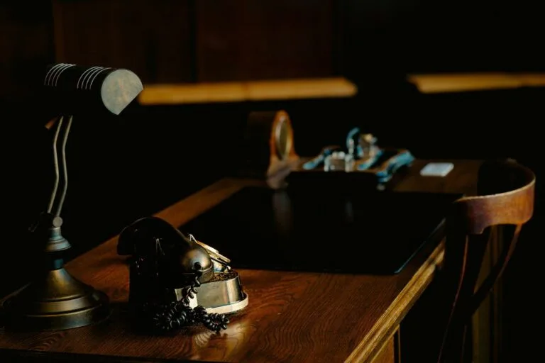Vintage desk with lamp and ornate object.