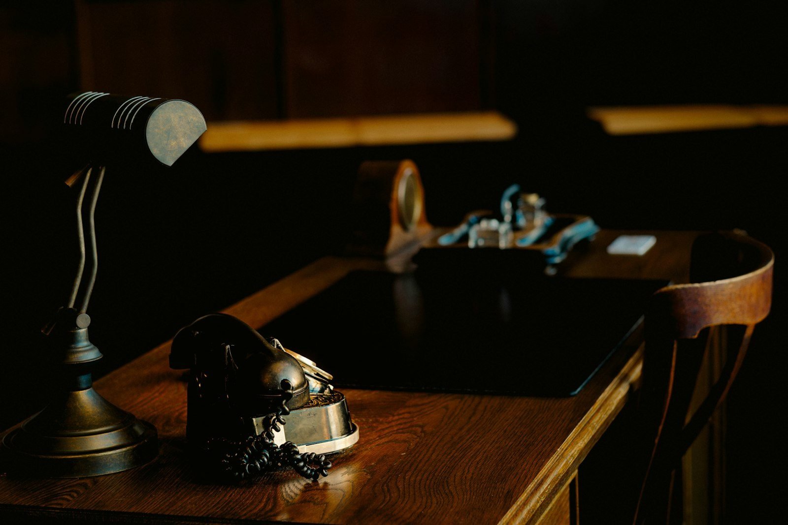 Vintage desk with lamp and ornate object.