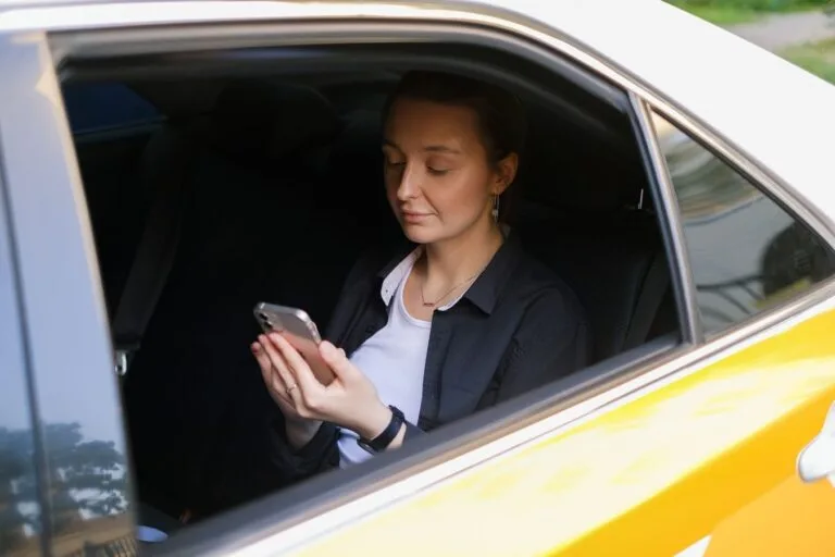 Passageira em carro de aplicativo de transporte usando o celular durante a corrida
