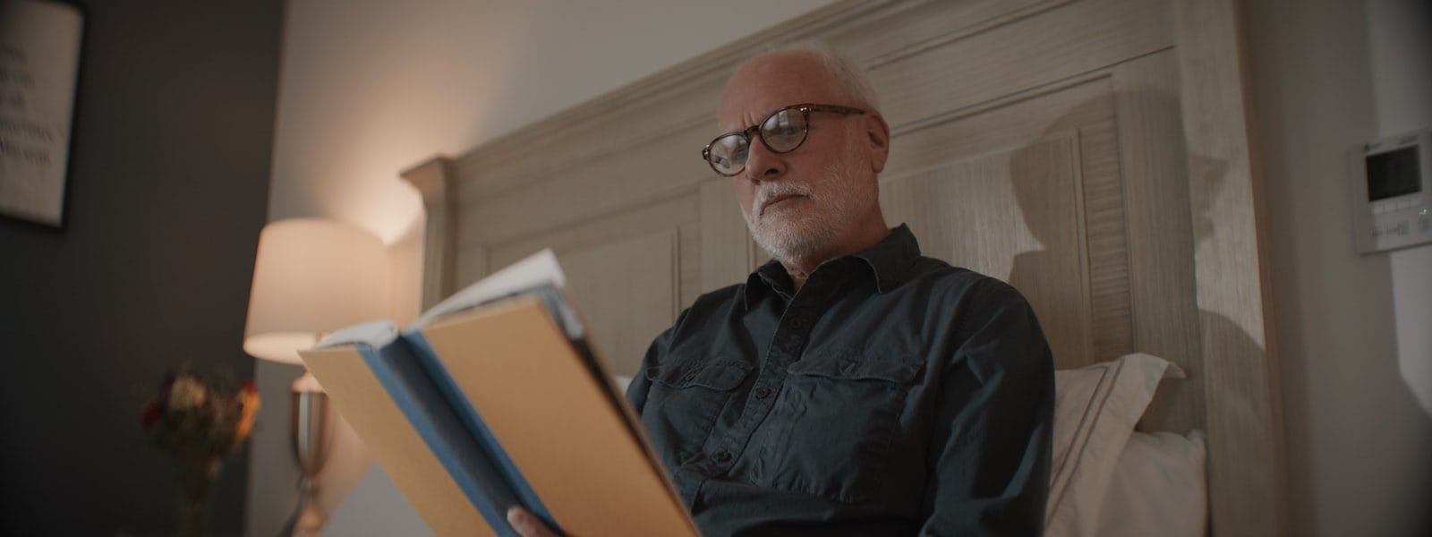 Aposentadoria de agentes de saúde: veja as novas regras 1 Senior man with glasses reading documents in bed.
