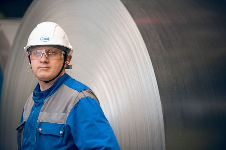 Aposentadoria especial: requisitos para quem trabalhou exposto a agentes nocivos 2 Portrait of a factory worker in protective gear in front of a large steel coil in an indus