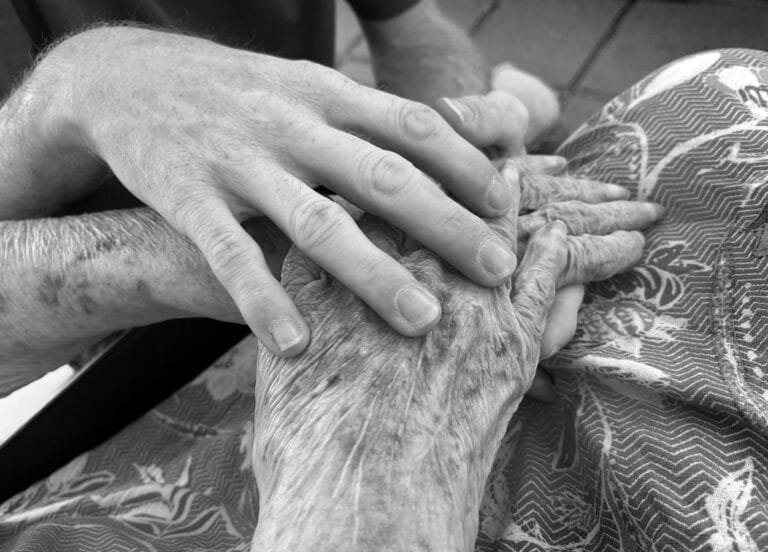 Como podemos ajudar? 9 Heartfelt image of an adult holding an elderly persons hand, symbolizing care and connection.