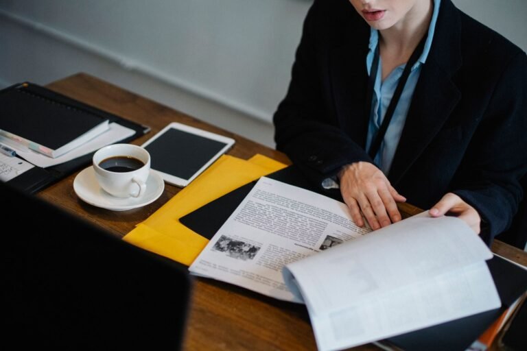 High angle of crop faceless businesswoman in formal clothes sitting at table with tablet a
