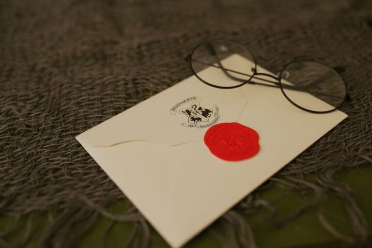 Resultados 2 A close-up of a sealed envelope with red wax and eyeglasses on a textured background.