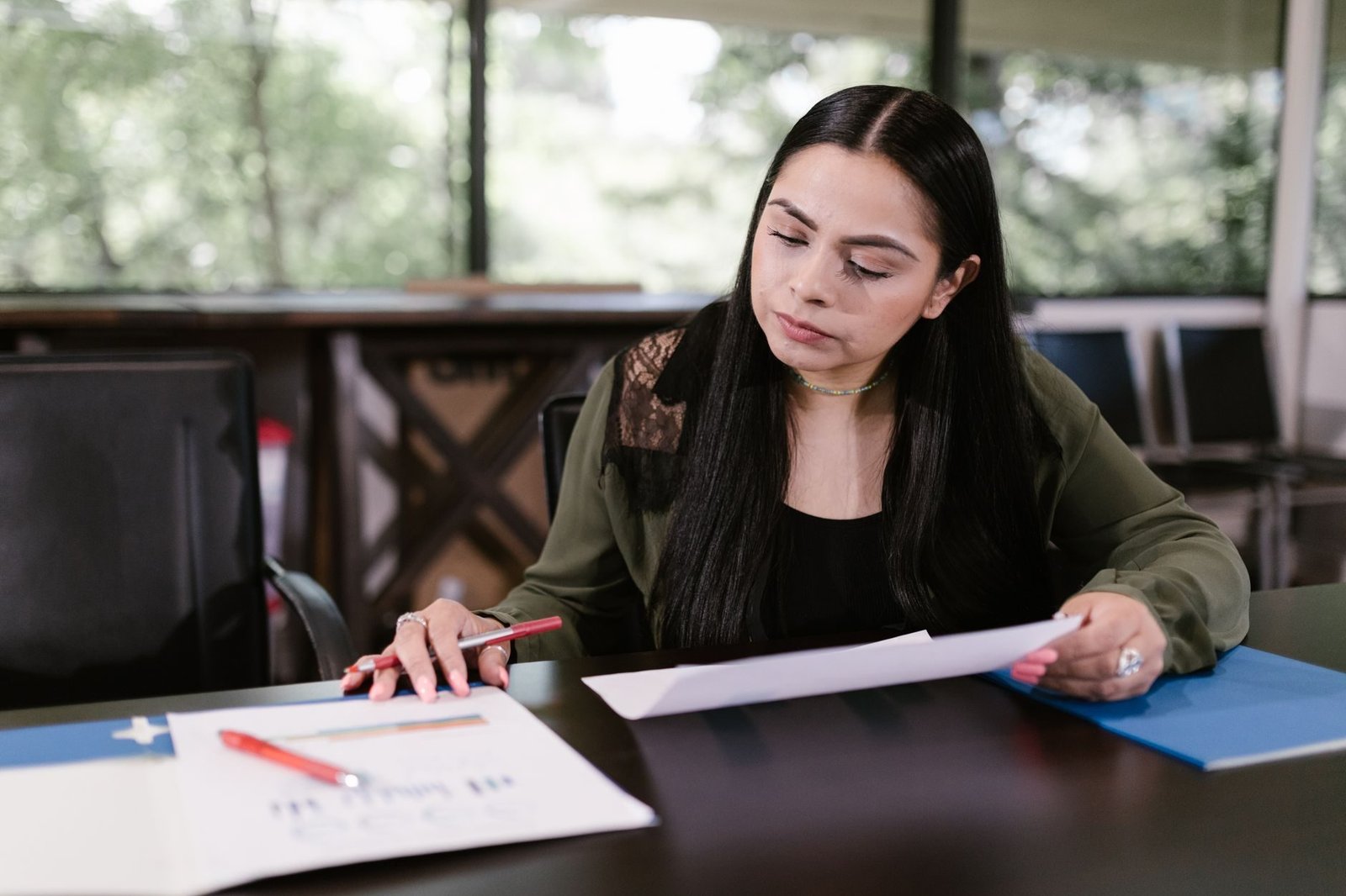 Calculo do valor da aposentadoria: como a media dos salarios define a renda mensal 1 Professional woman in office setting studying documents with concentration.