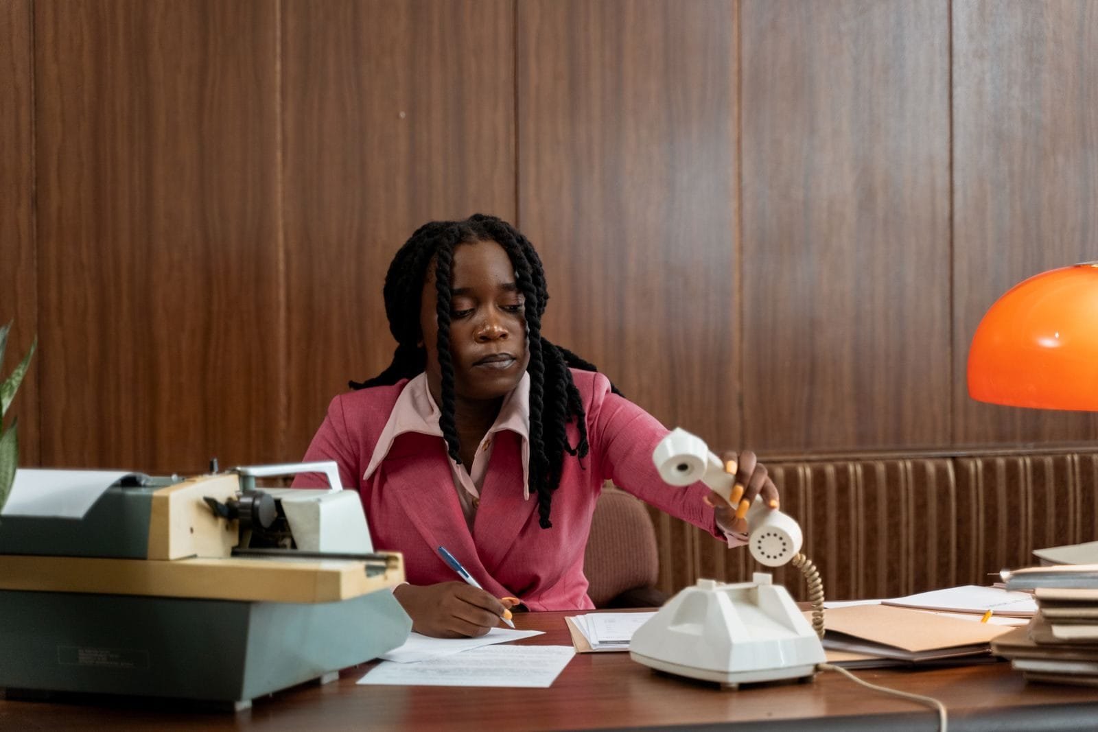 Certidão negativa de débitos: para que serve e como obter sem surpresas 1 An adult woman in a vintage office setting, handling a rotary phone.