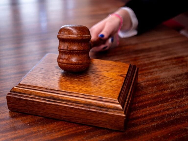 Close-up of a wooden judges gavel on a desk in a courtroom, symbolizing justice.