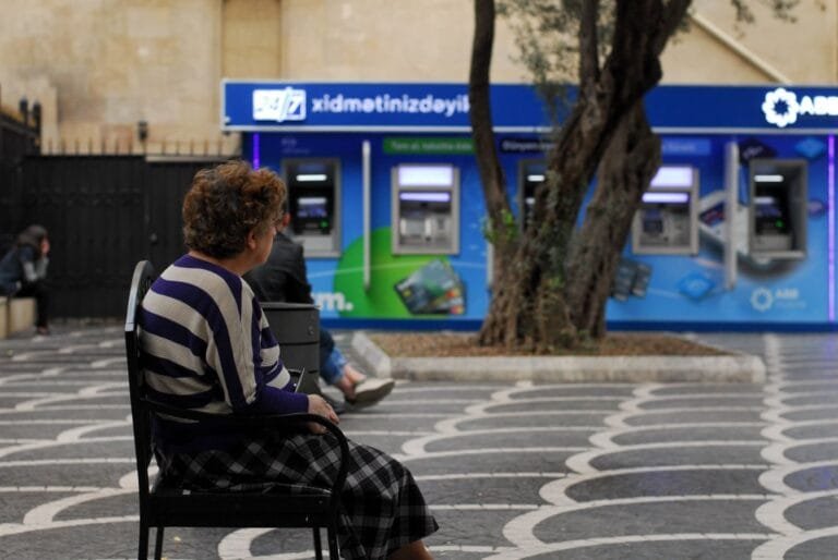 Como o bancário prova a equiparação com o colega paradigma 5 Senior woman seated near automatic teller machines in Baku, Azerbaijan.