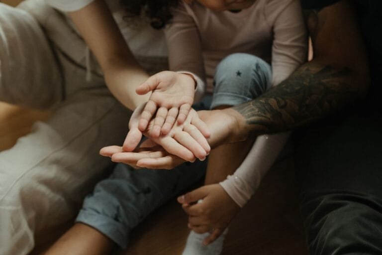 Como podemos ajudar? 6 Close-up of diverse family hands symbolizing connection and warmth.