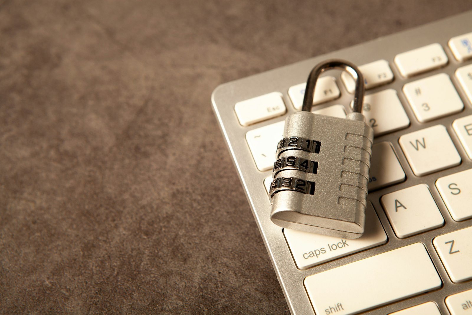 A padlock rests on a computer keyboard.