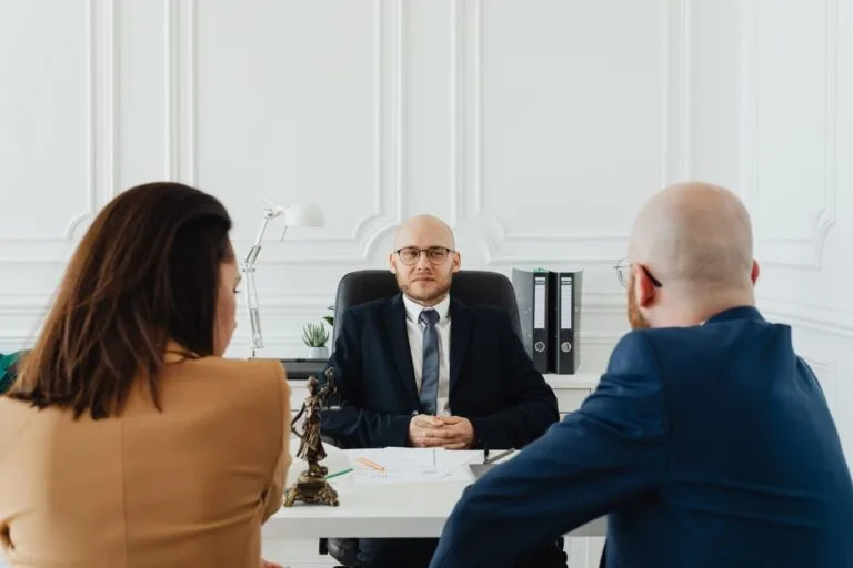 Conflito de interesses na advocacia: como a ética protege quem contrata 8 Lawyer meeting with clients in a formal office setting for legal consultation.