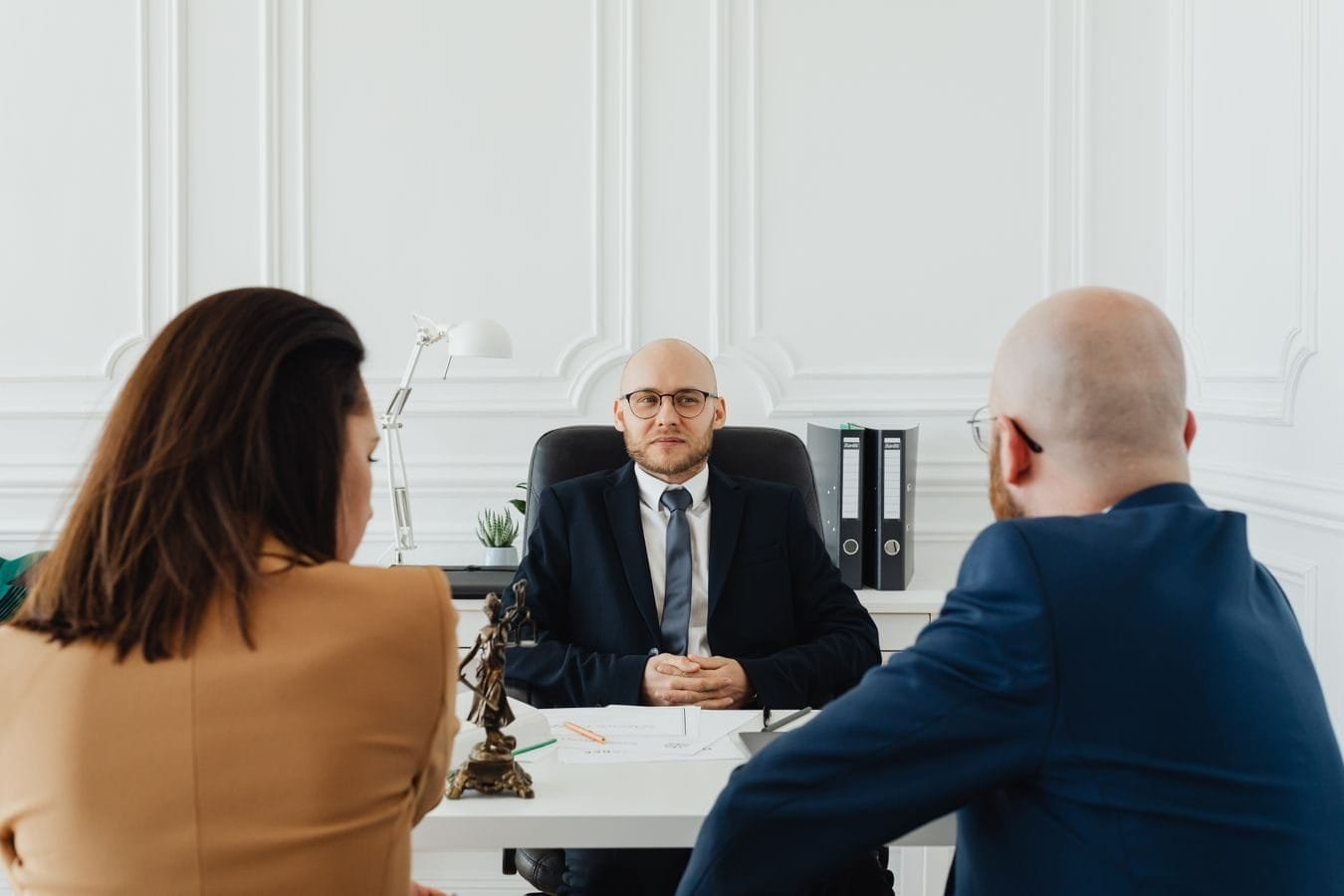 Conflito de interesses na advocacia: como a ética protege quem contrata 1 Lawyer meeting with clients in a formal office setting for legal consultation.