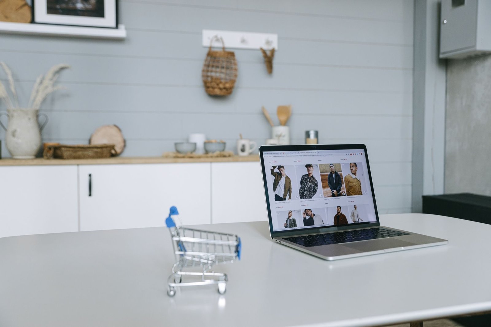 Contratos empresariais: clausulas essenciais que evitam prejuizo em qualquer negociacao 1 A laptop displaying an online shopping portal sits on a minimal desk with a miniature shop