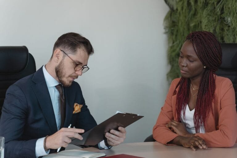 Cotas raciais em concursos: heteroidentificação e segurança jurídica 2 A man and woman engaging in a job interview in a modern office setting.