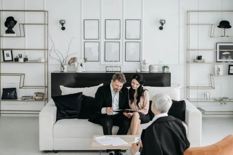 Couple consulting with a social worker in a modern living room setting, discussing documen