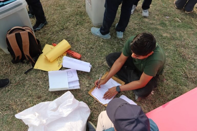 Direito de peticao e o uso correto do processo administrativo pelo cidadao 7 Man sorting electoral papers outdoors in Nepal for upcoming election.