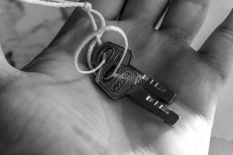 Documentos e cuidados antes de comprar um imovel usado para nao herdar problemas 5 Detailed black and white photo of keys held in a hand, emphasizing texture and detail.