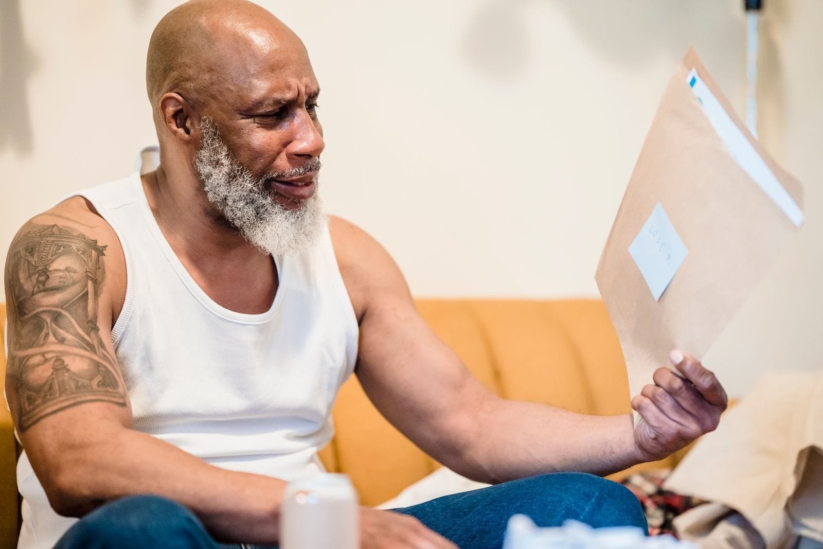 Senior man looking stressed while reading financial documents at home.