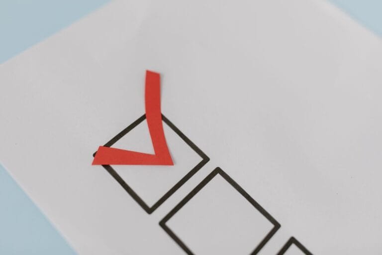 Habilitação na licitação: documentos que costumam derrubar a proposta 3 Close-up of a red check mark on a crisp white paper with black boxes, symbolizing completion.