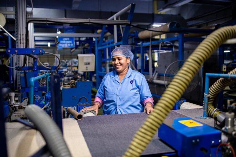 A woman working in a bustling textile factory, surrounded by machinery.