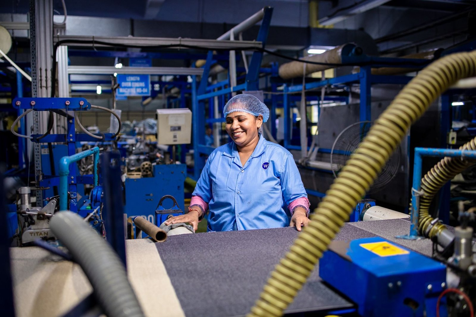 A woman working in a bustling textile factory, surrounded by machinery.