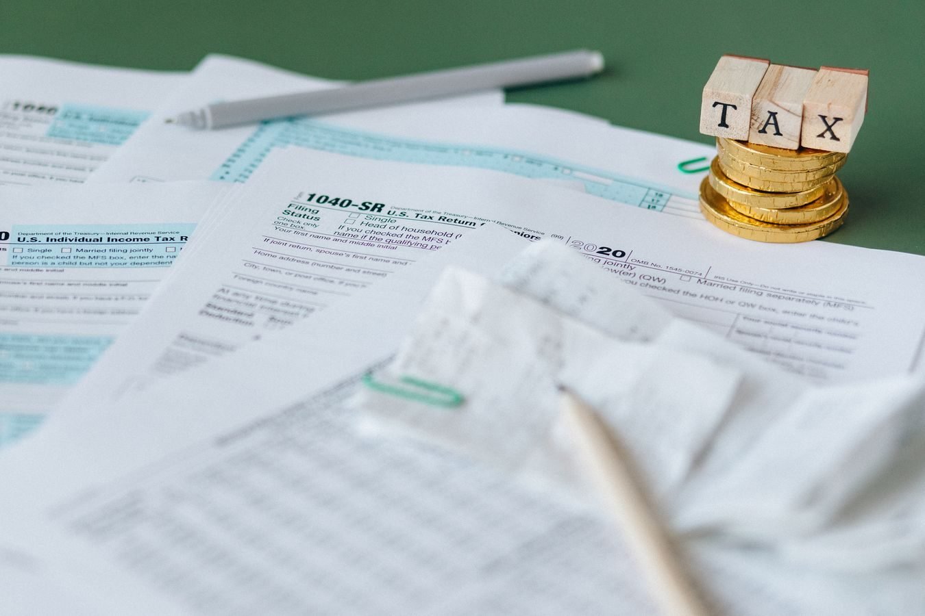 Imunidade e isencao tributaria: por que nao sao a mesma coisa 1 Stack of tax forms and coins with a TAX stamp, symbolizing finance and accounting.