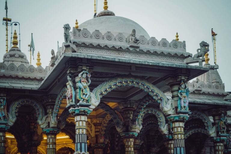 Intricate exterior of a Hindu temple showcasing colorful sculptures and detailed columns.